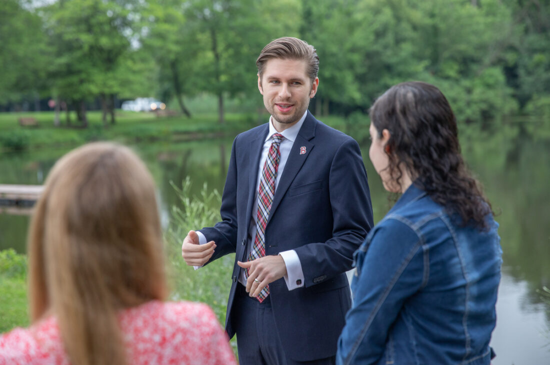 Alumni speaking with students by Lake St. Benedict