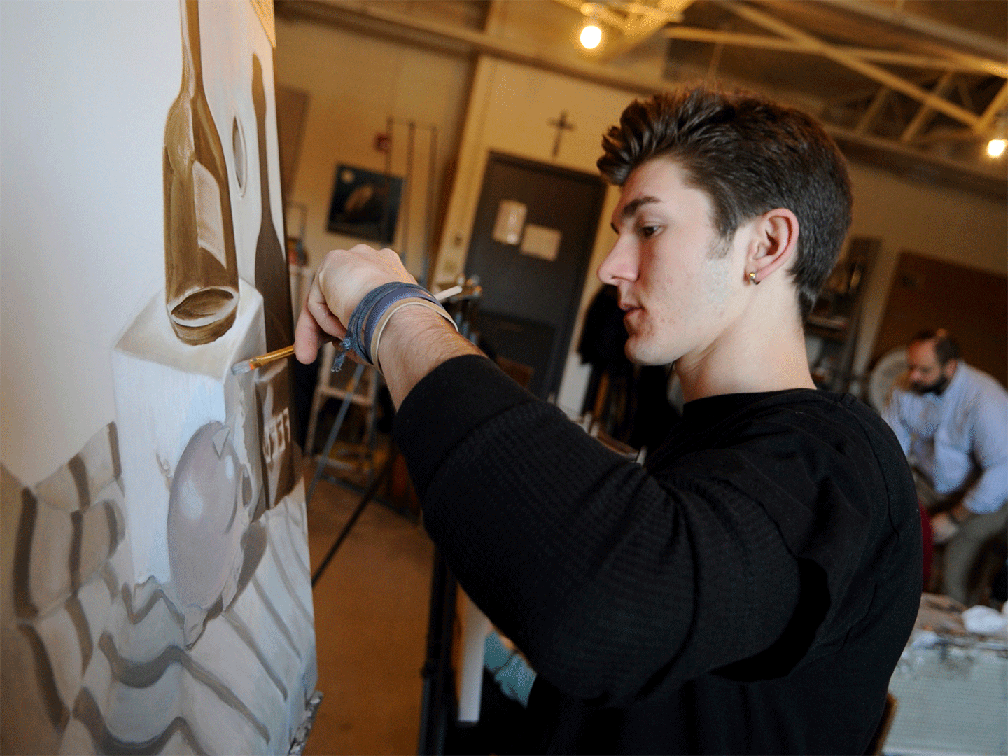 male student painting in the College of Liberal Arts