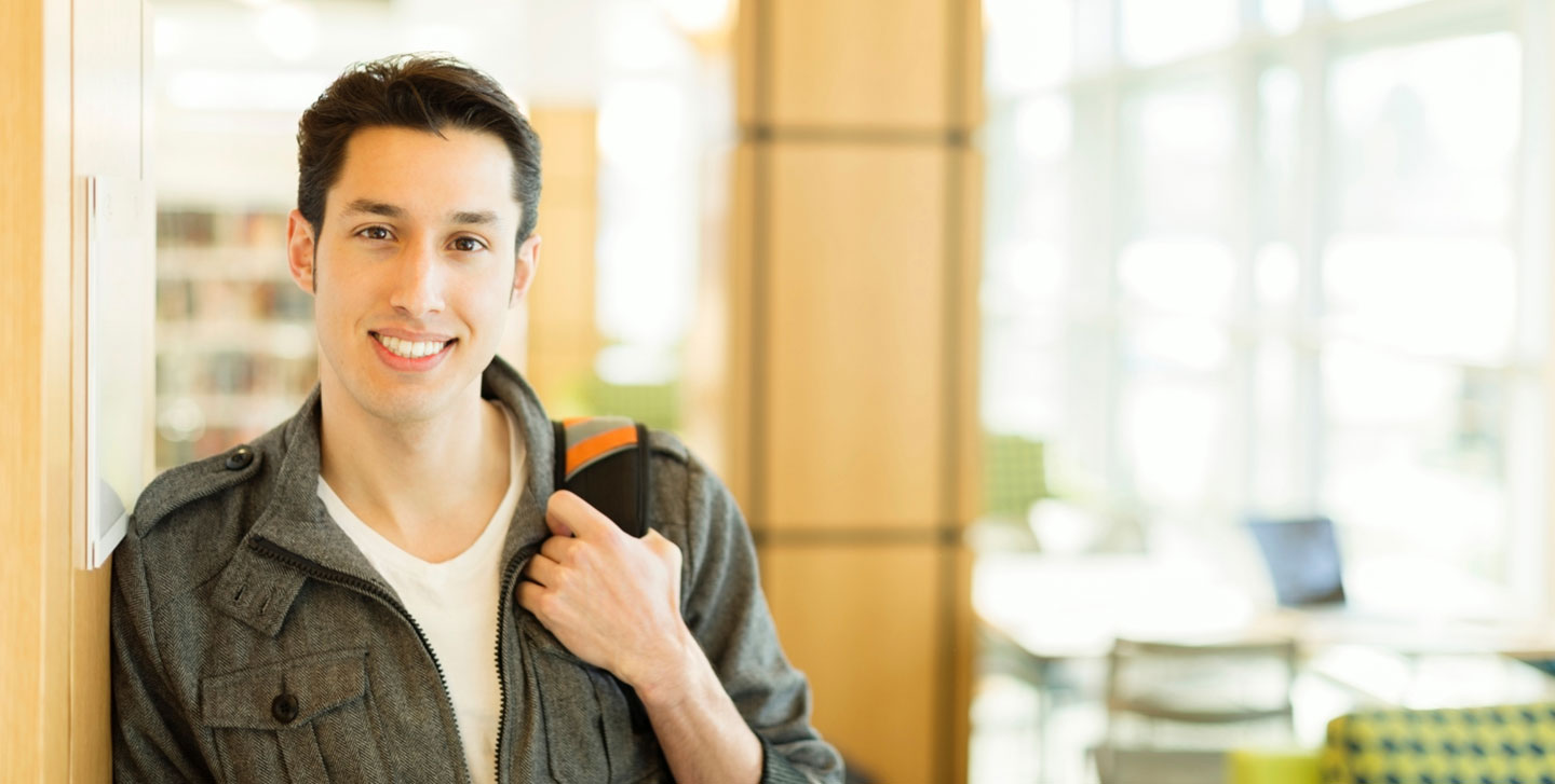 male student leaning with a backpack