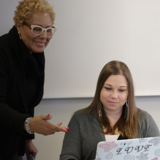 Female faculty member helping a student on her computer