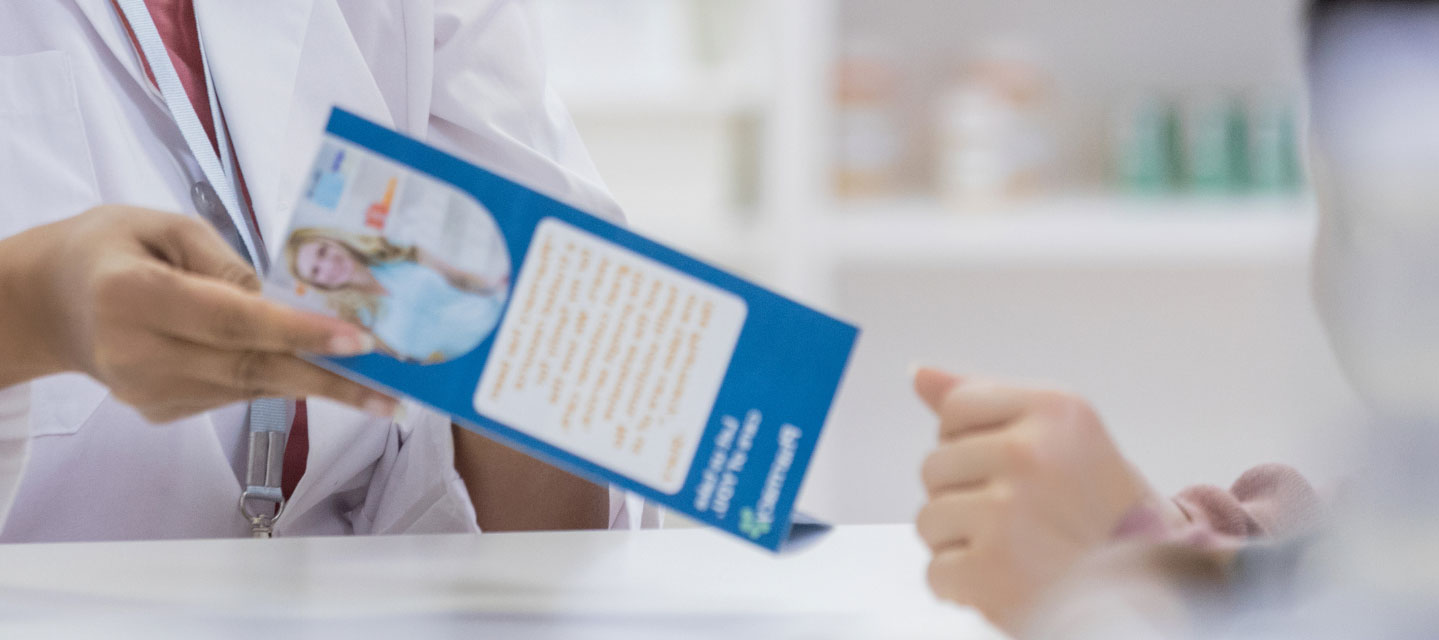 health care professional handing pamphlet to person; health education and promotion