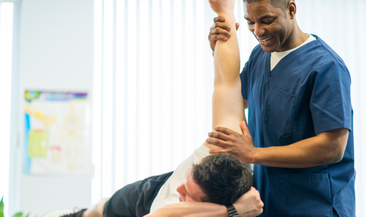 physical therapist helping patient stretch his shoulder; pre-physical therapy