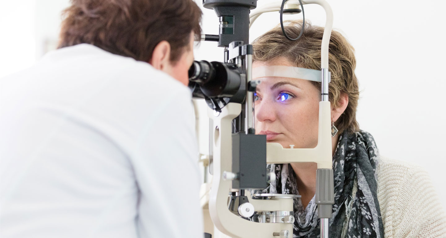 optometrist using equipment to look into a patient's eyes; pre-optometry