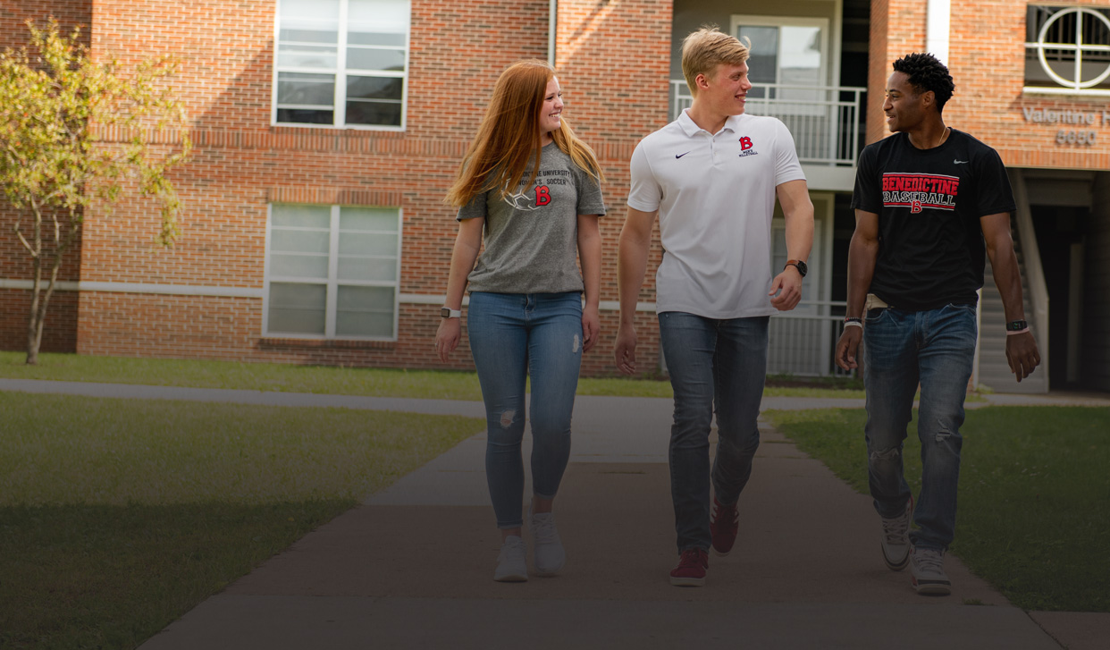 Three students walking away from campus housing building talking together; transfer and degree completing student housing