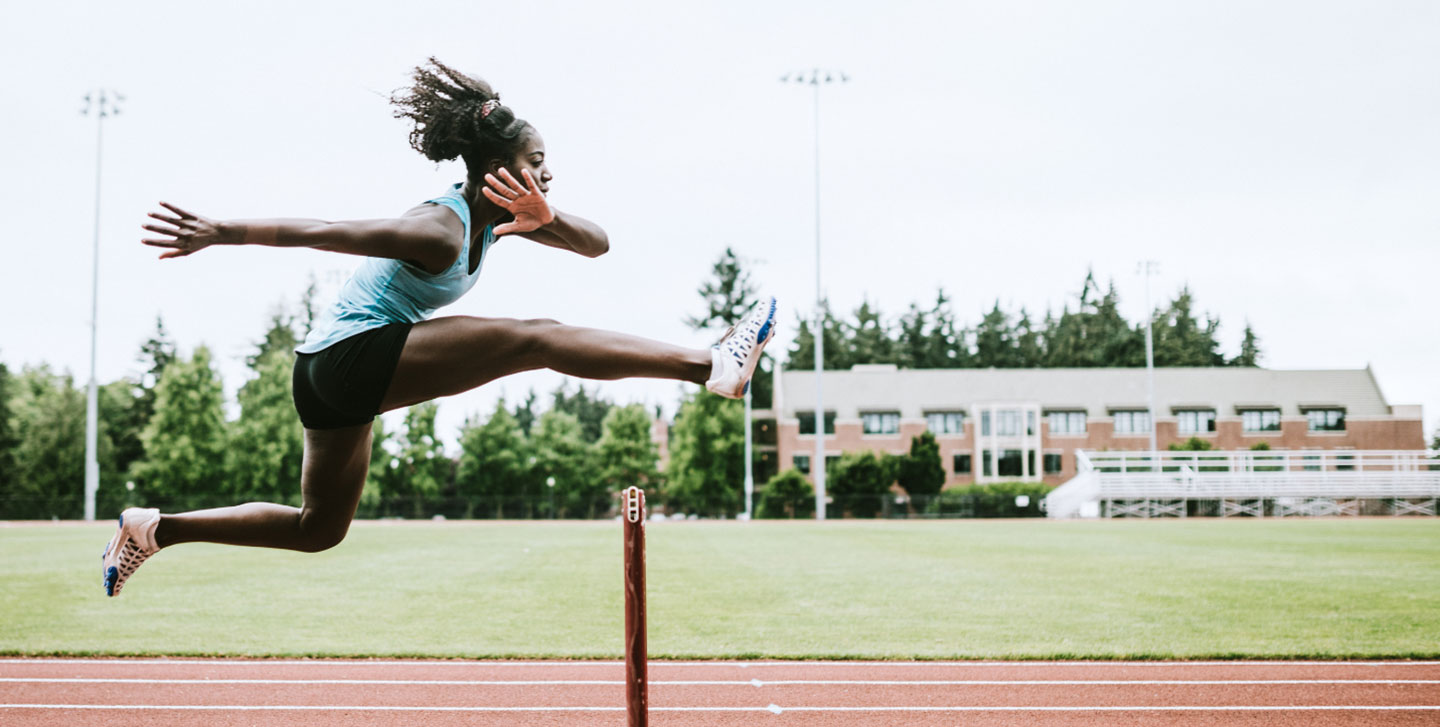 female athlete jumping over a hurdle; strength and conditioning minor