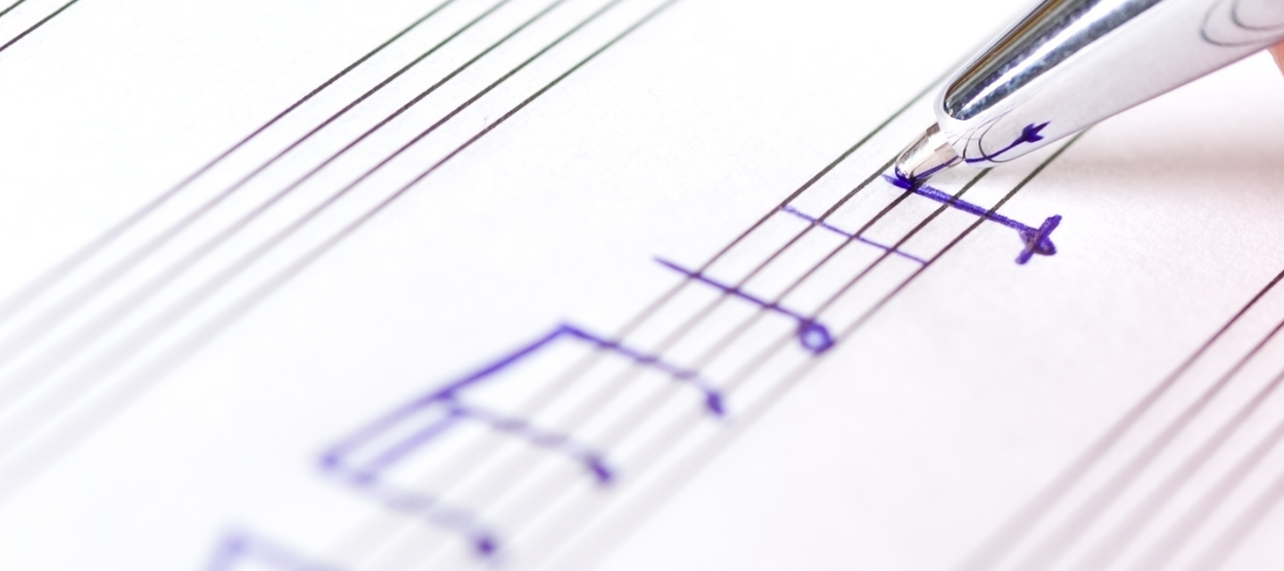 pen drawing music notes on blank staff paper; music