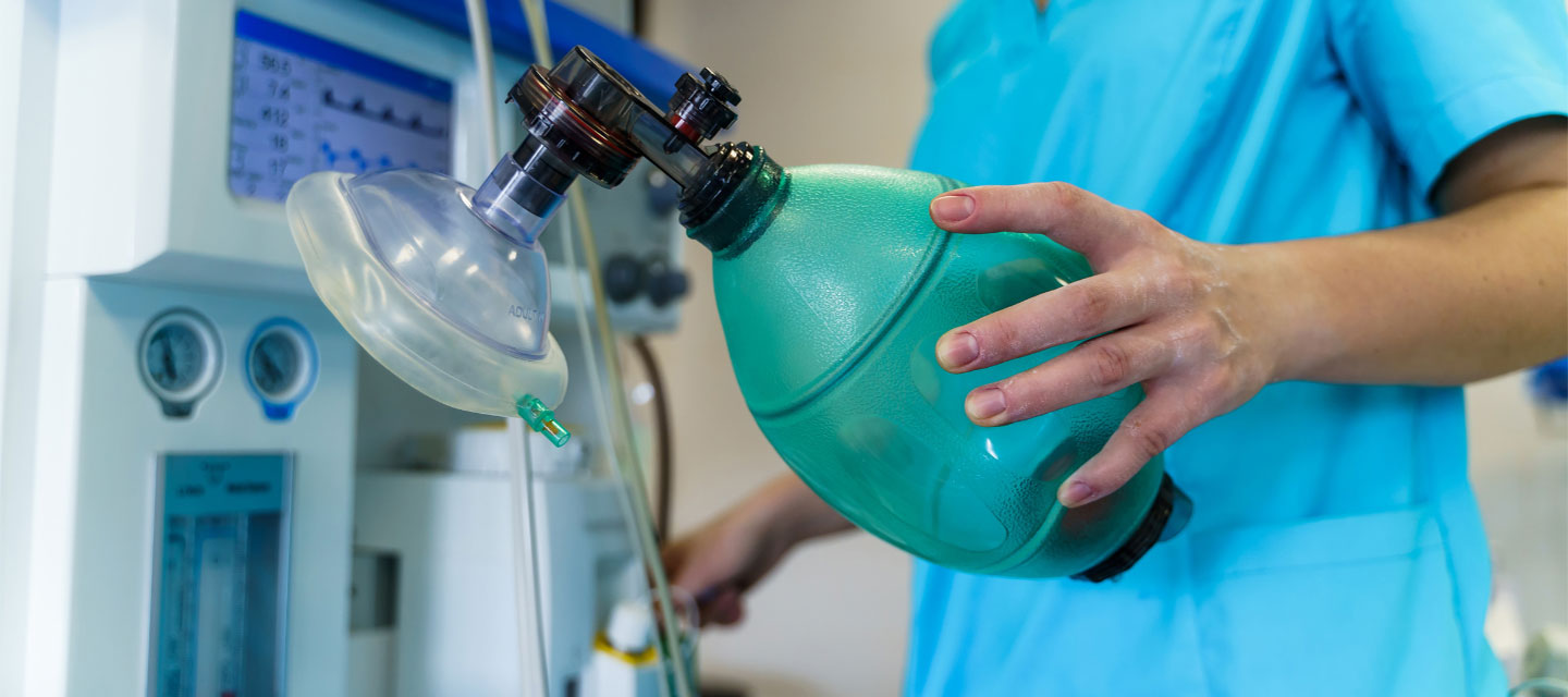 female respiratory therapist holding an oxygen assistance mask; respiratory care