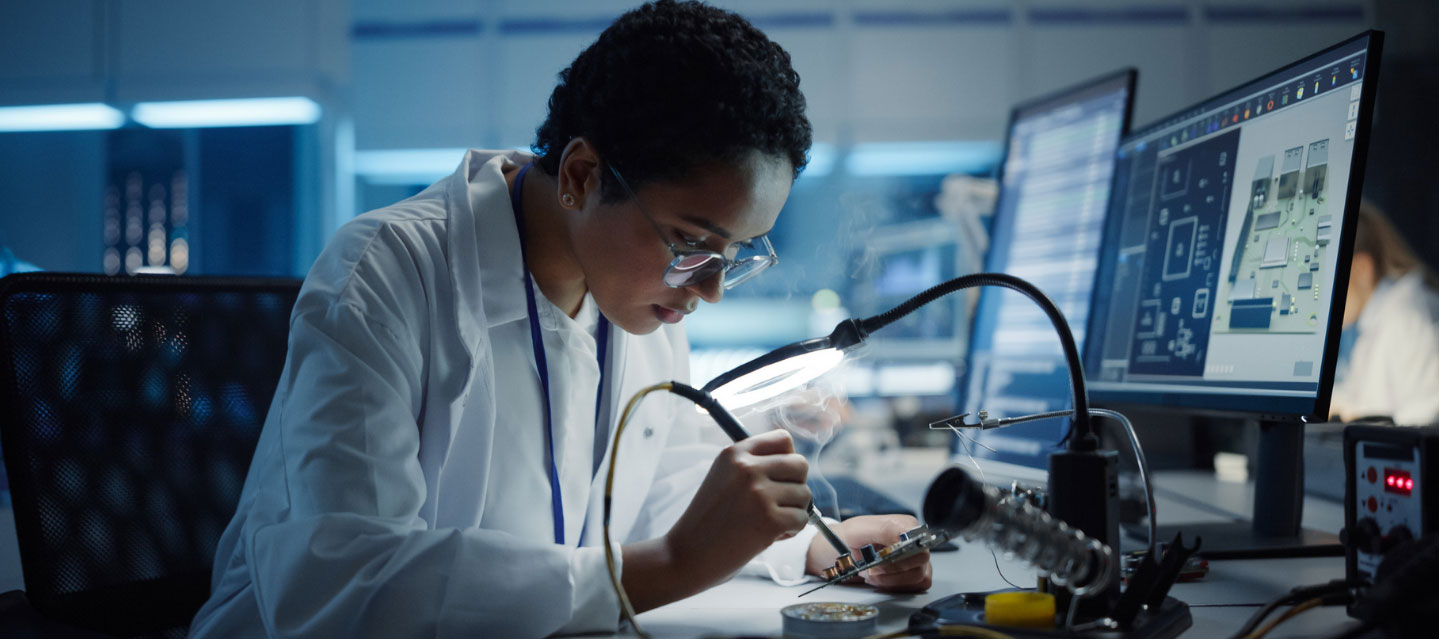 student working in lab with computer screens; computer science
