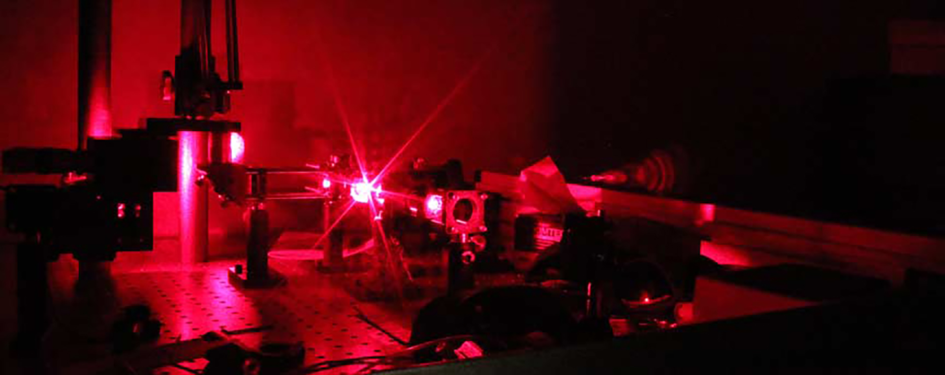 red laser glowing very brightly in equipment that is running experiment; physics