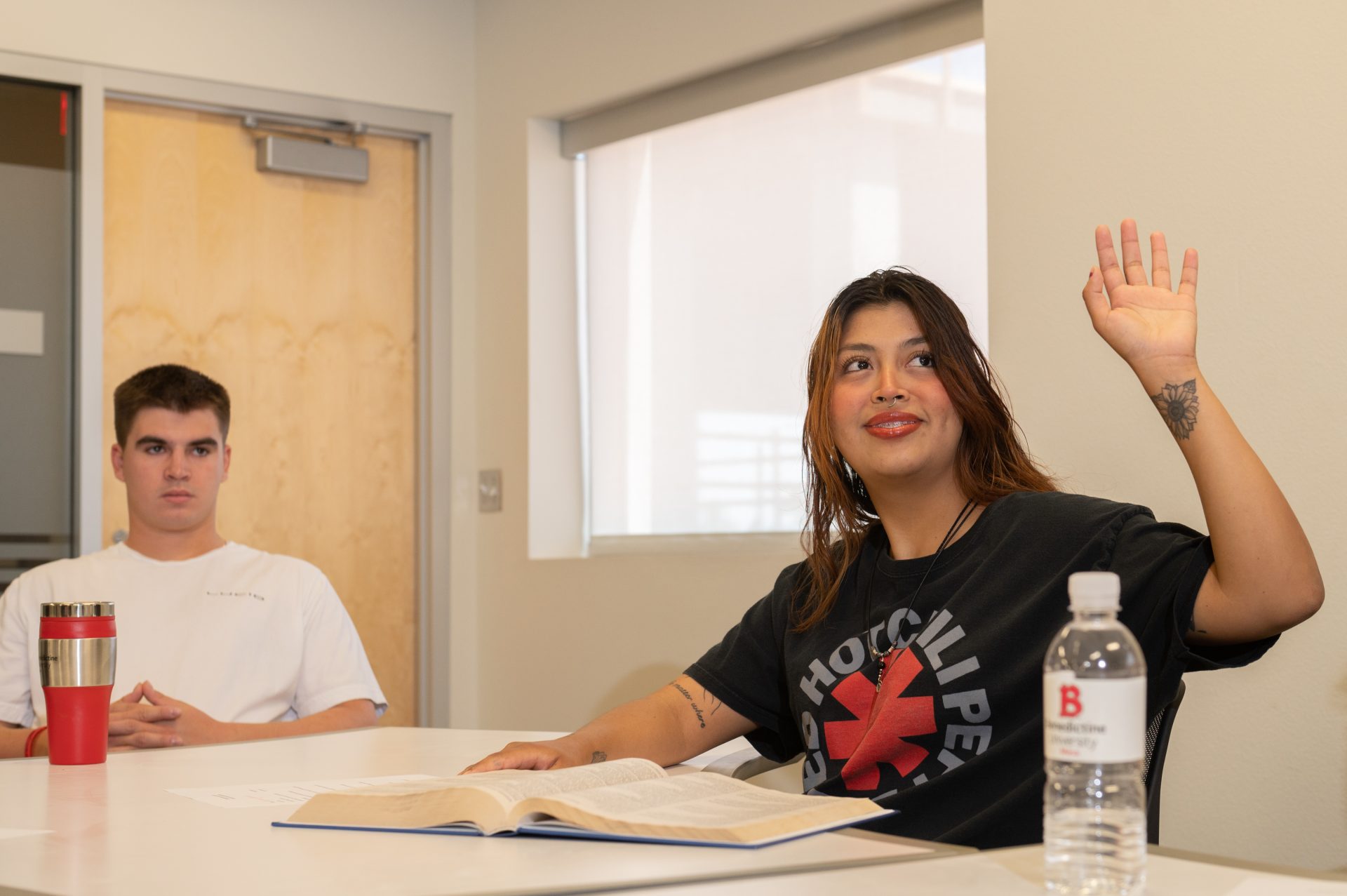 mesa, female student raising her hand in class