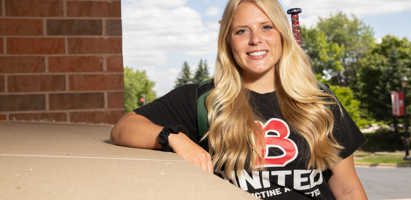 Female softball student leaning on the ledge of Birck Hall; Scholarship
