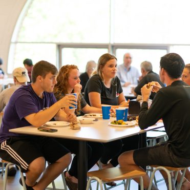 Students at a table in Benny's eating lunch - Residence Hall dining information