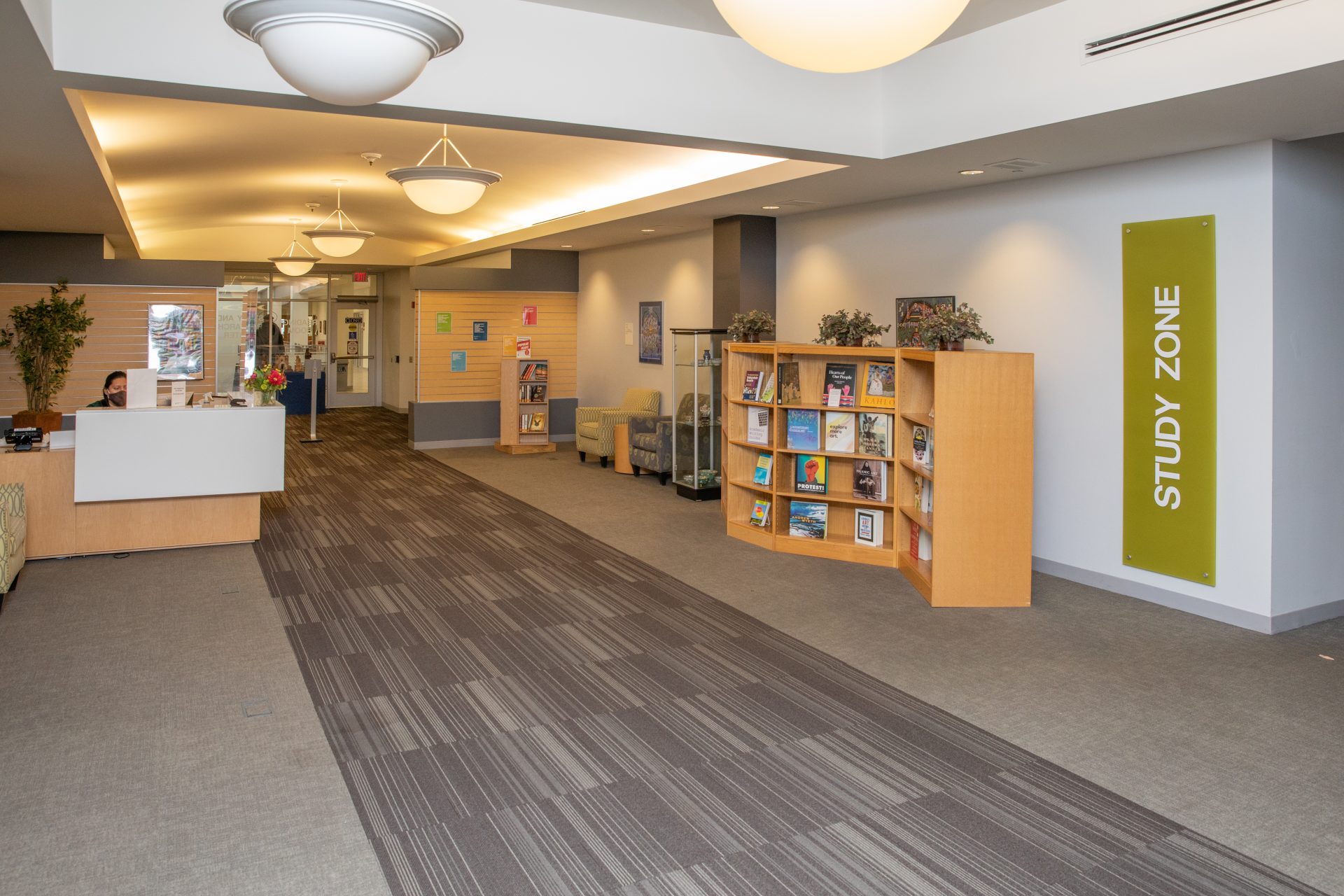 picture of the Benedictine Lisle library entrance with circulation desk and bookshelf visible