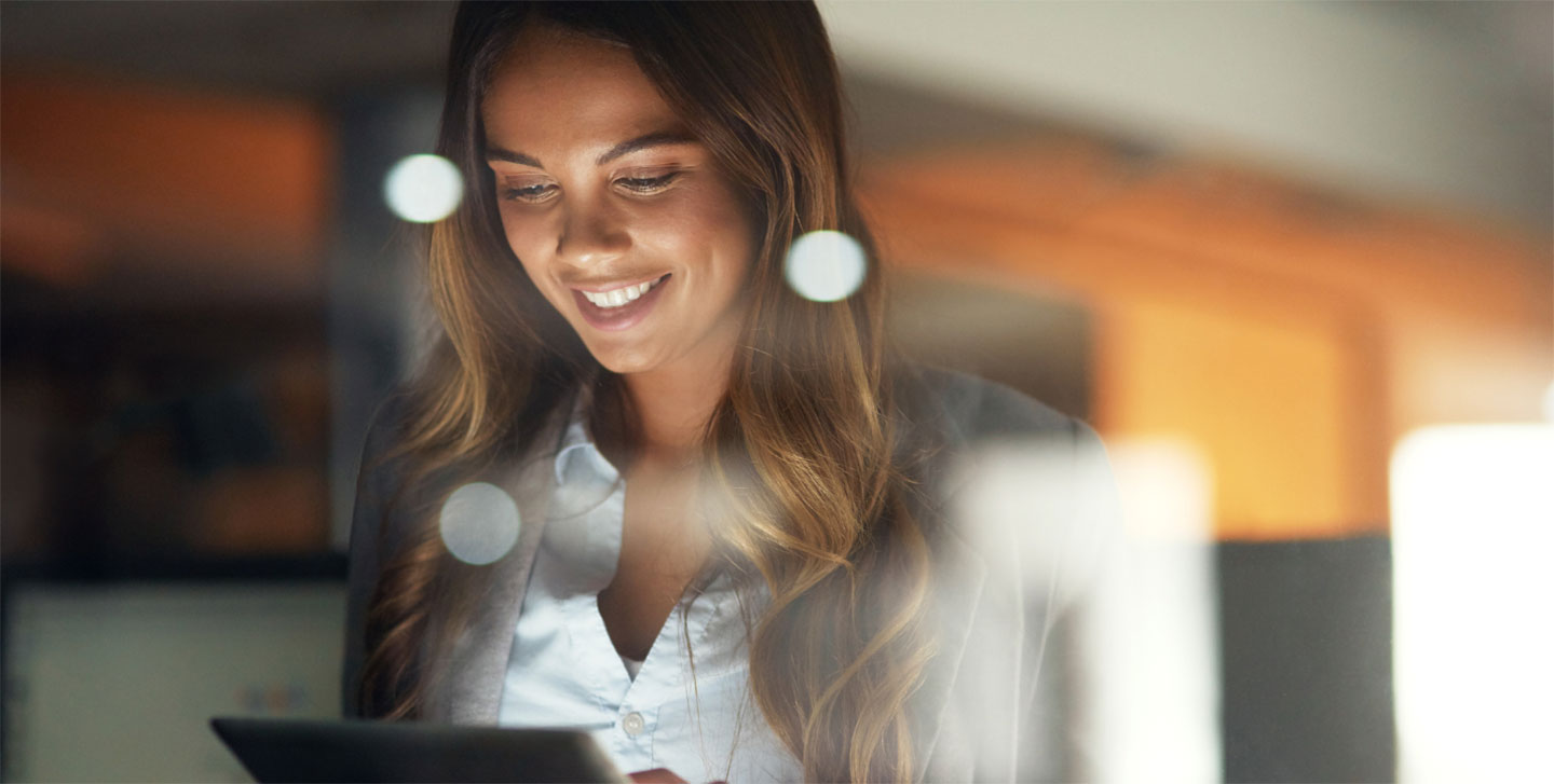 female professional reading an iPad smiling with a dotted overlay on the photo; organizational development program