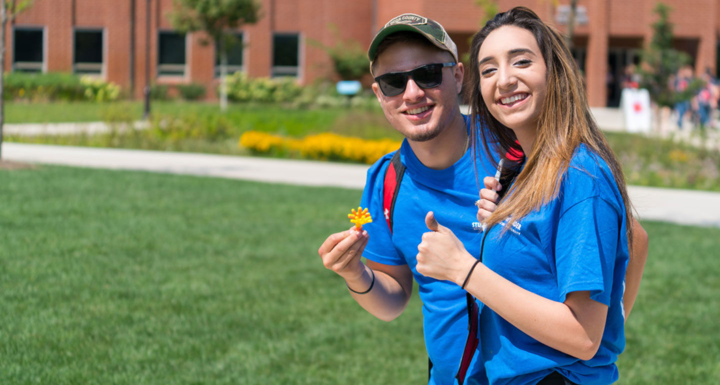 male and female students in blue shirts walking on Quad. Transfer scholarships