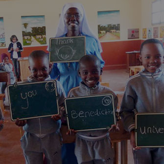 Tanzania students with Sr. holding up Thank You message on chalk boards