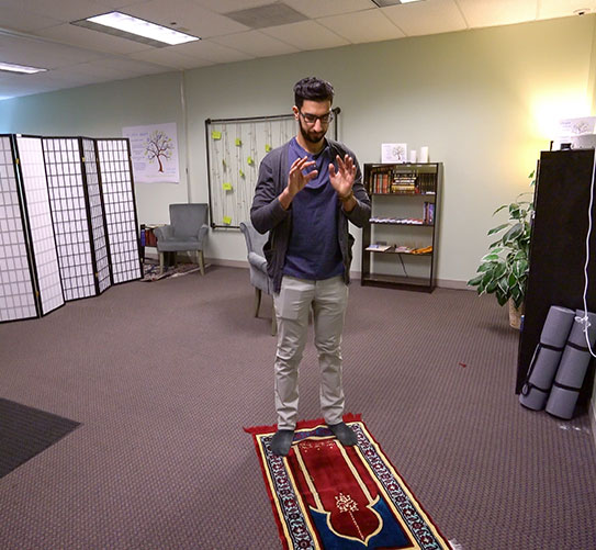 Male student praying in Campus Ministry's Interfaith Prayer Room