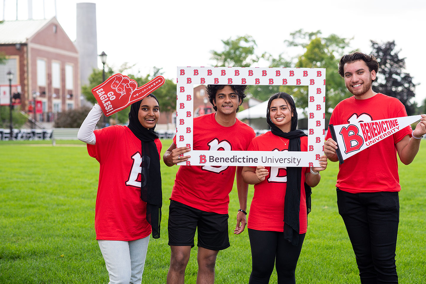 BenU students with spirit on the quad with a BenU Frame, pendant, and foam finger