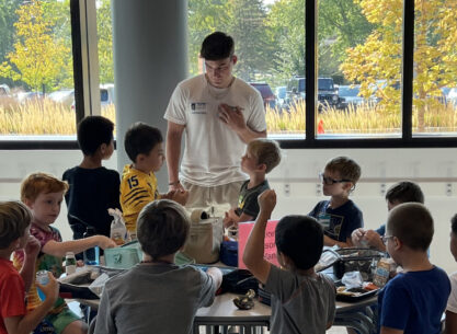 Men's basketball player visiting with students at elementary school