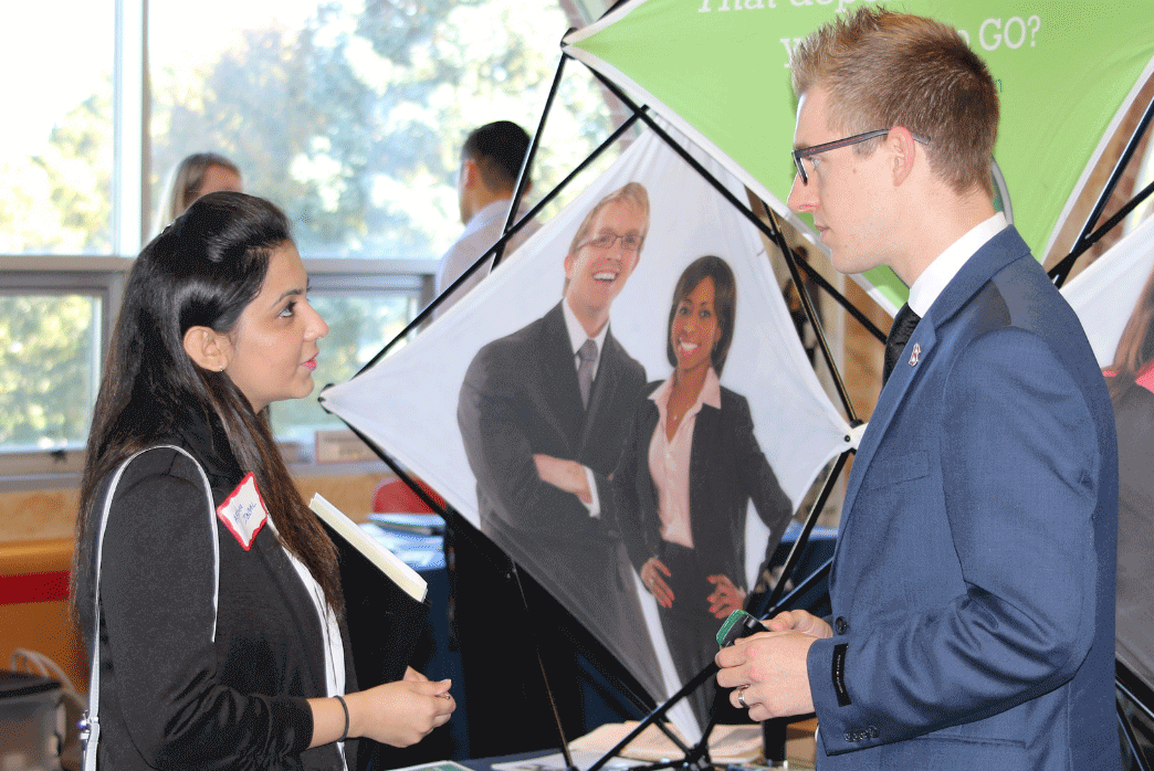 Career and Personal Development, female student talking to recruiter at job fair