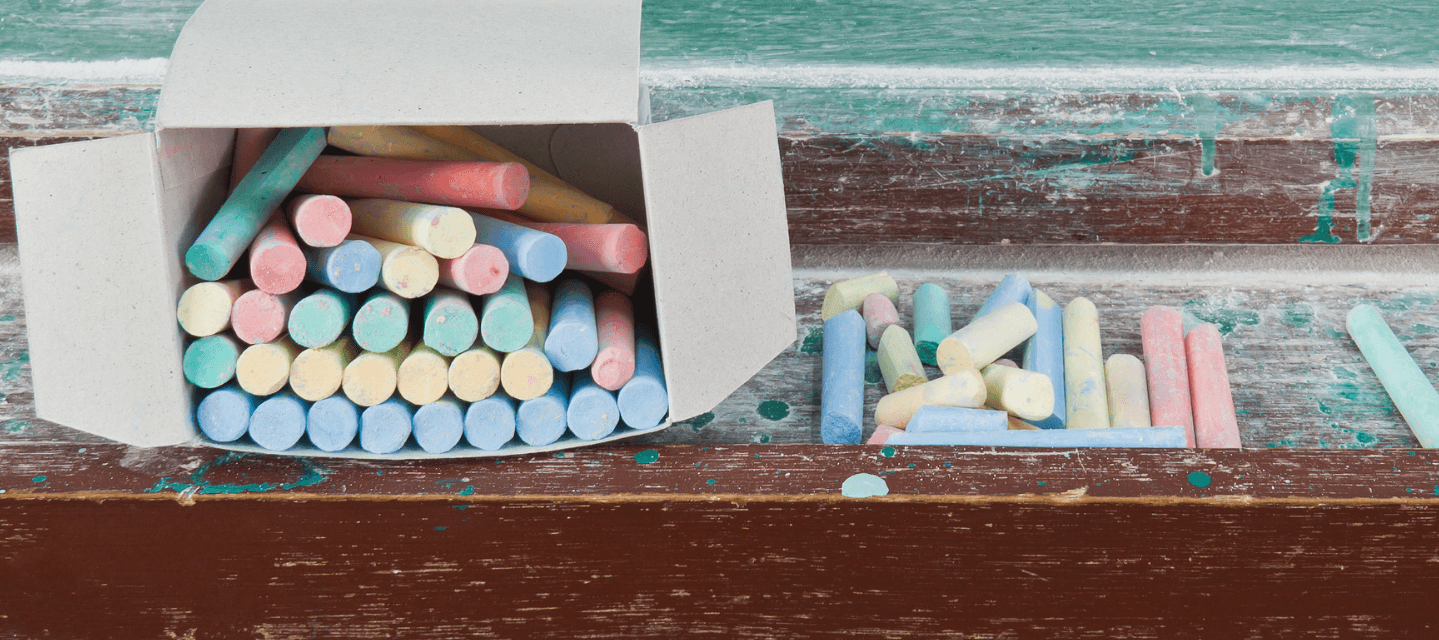 open box of colorful chalk and chalked table