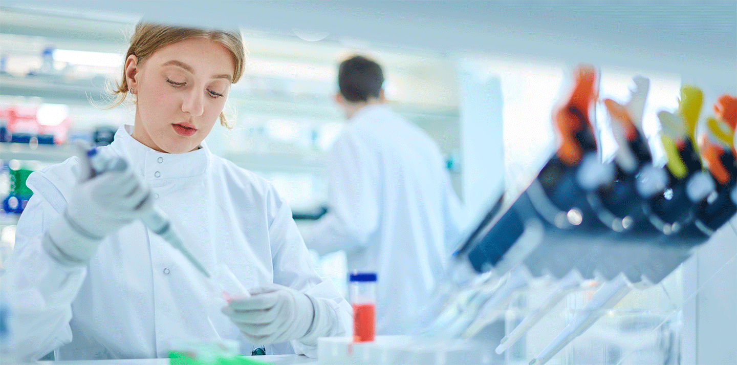 female student in lab coat doing experiment; pre-profession programs, dual acceptance