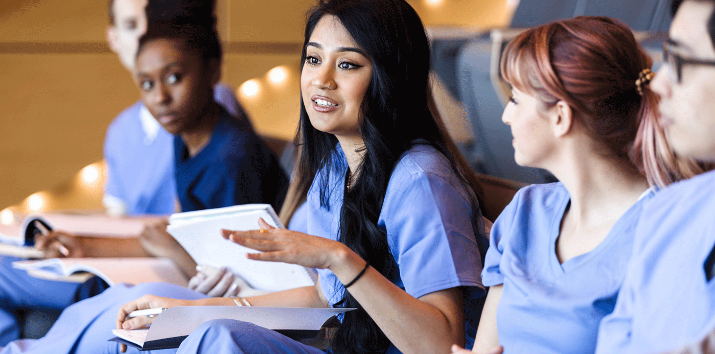 female Pre-professional students in scrubs in lecture setting