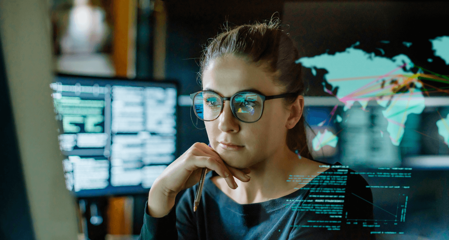 female looking at computer screen with images reflecting in her glasses