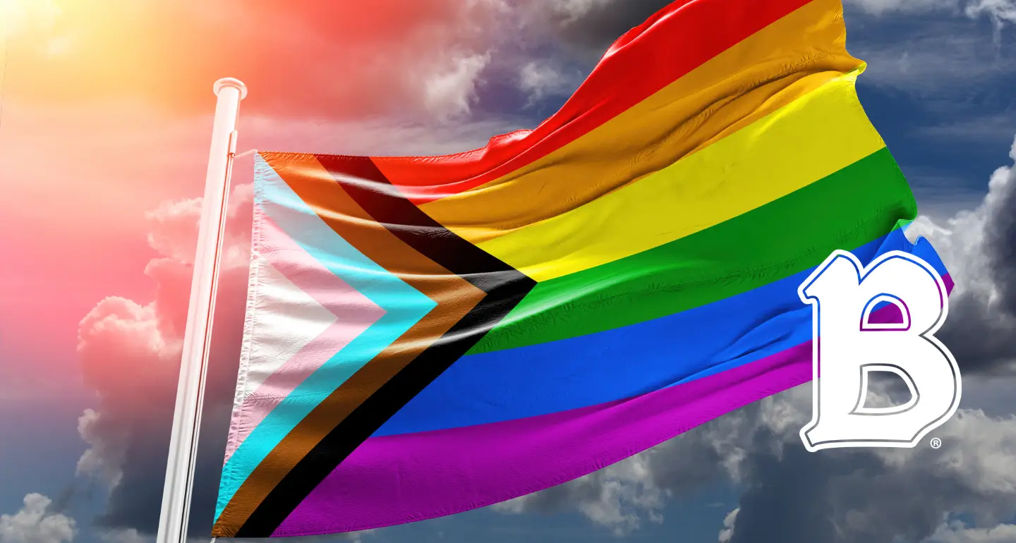 pride flag with Benedictine B against a sky background