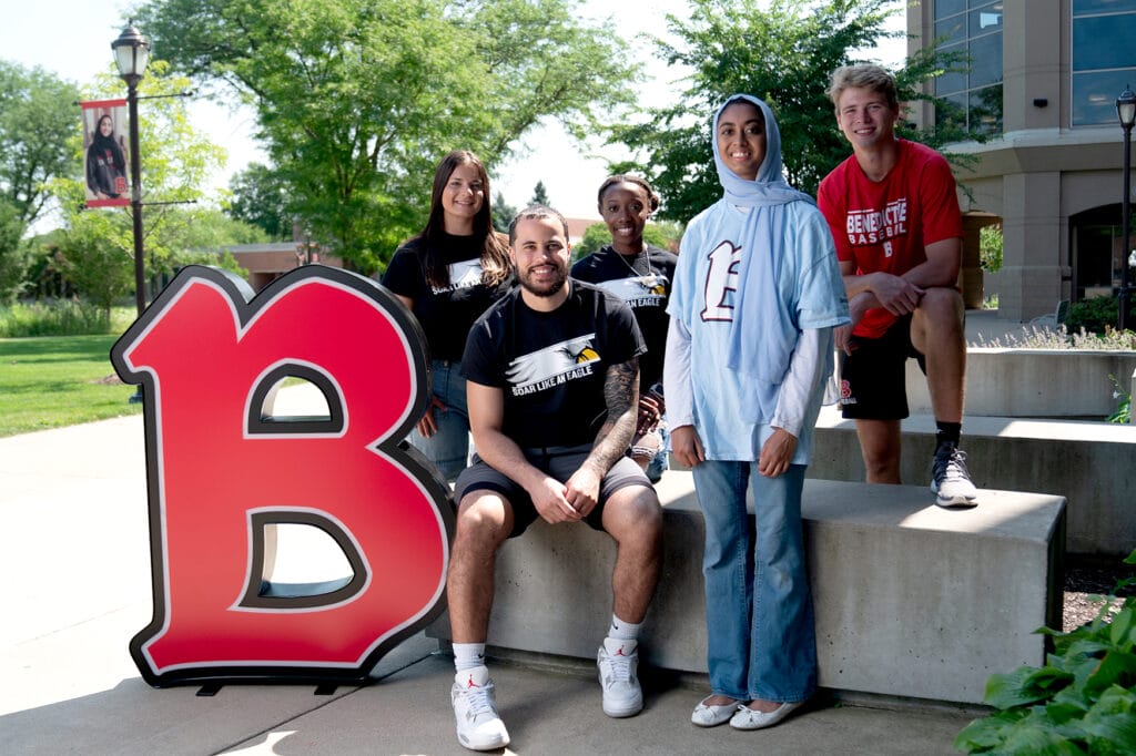 Group of students posing next to B