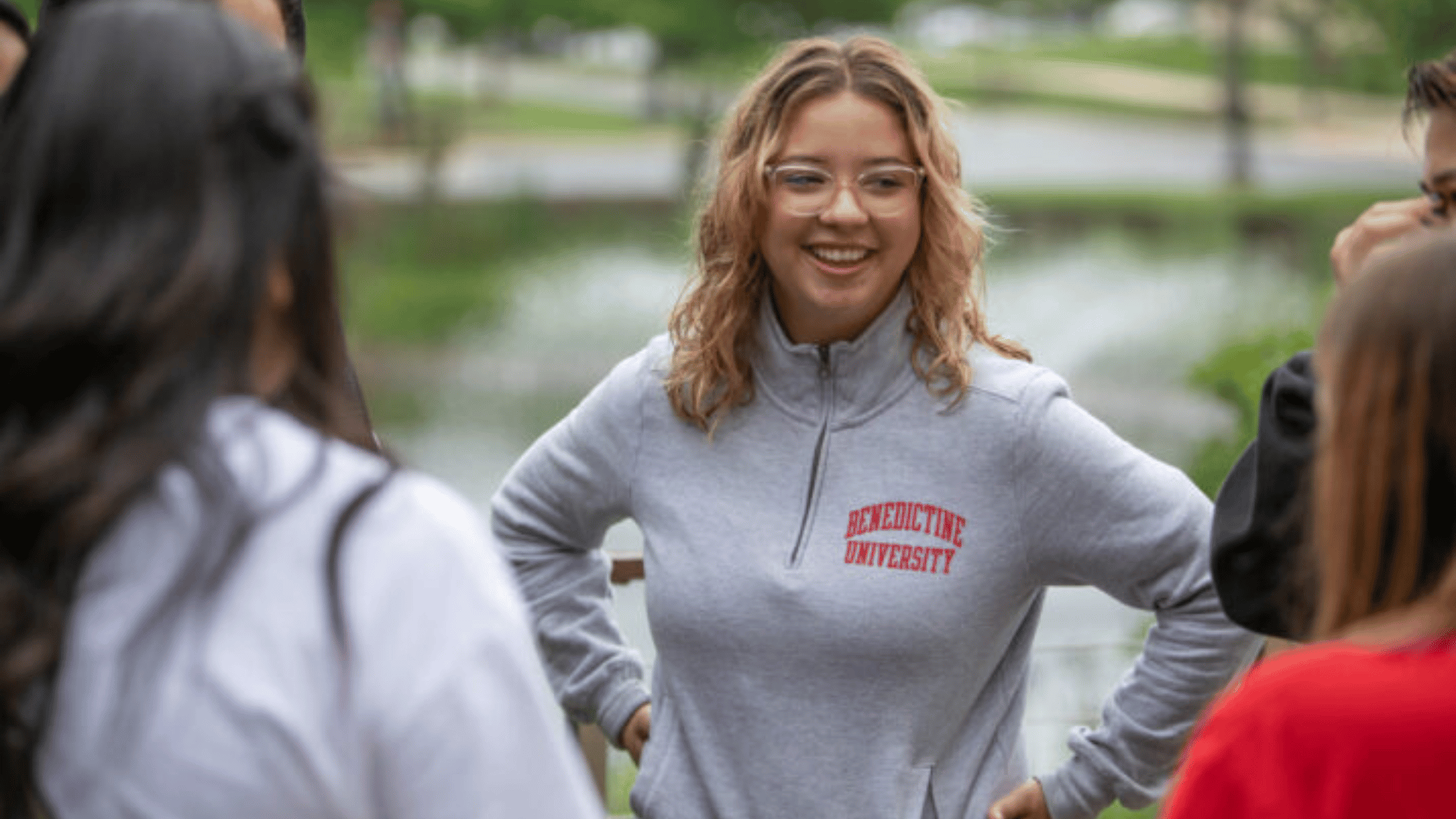 female student with arms on hips in gray Benedictine shirt