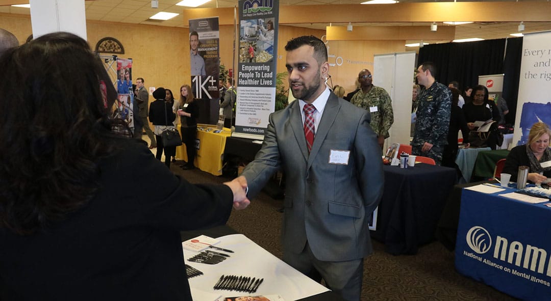 Career Fair 2017 - student in suit shaking hands with employer