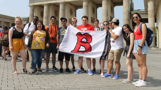 Study Abroad fee based, Study Abroad group of students posing with B flag